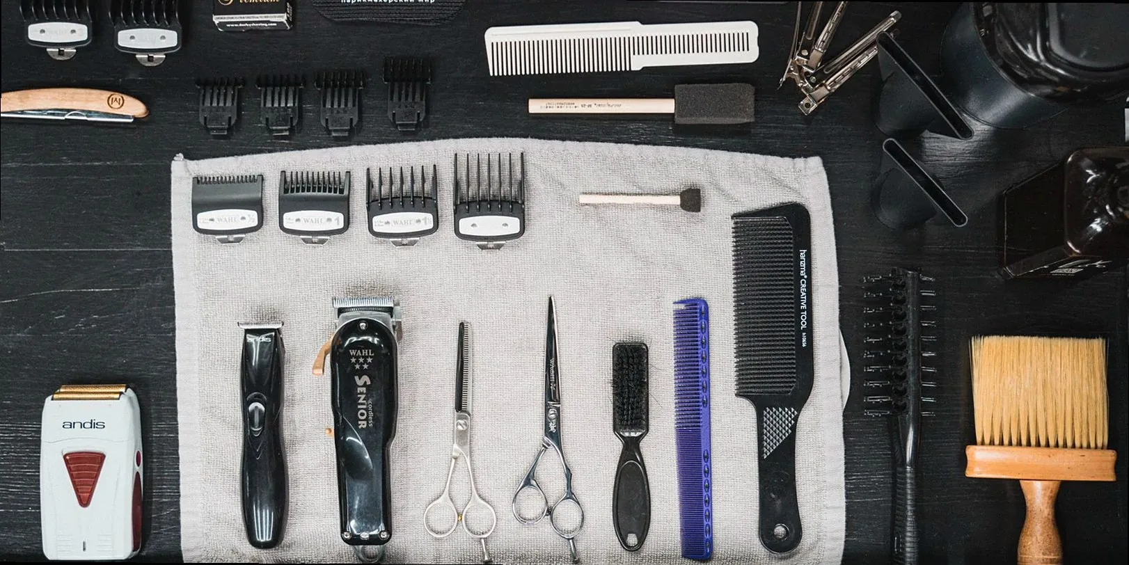 Professional hairdressing tools meticulously arranged in a flat lay, showcasing combs, clippers, scissors, and more.